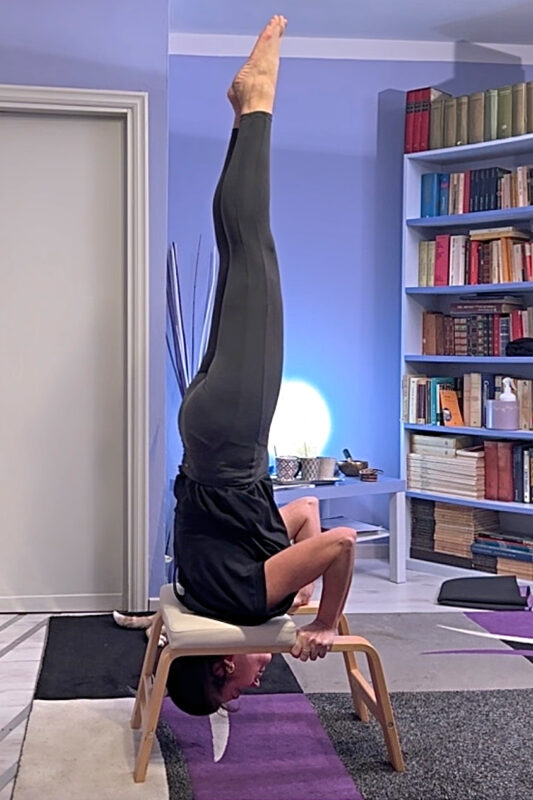 Yoga posturale asana sirsasana con aiuto del feetup Centro Sorigkhang Bologna